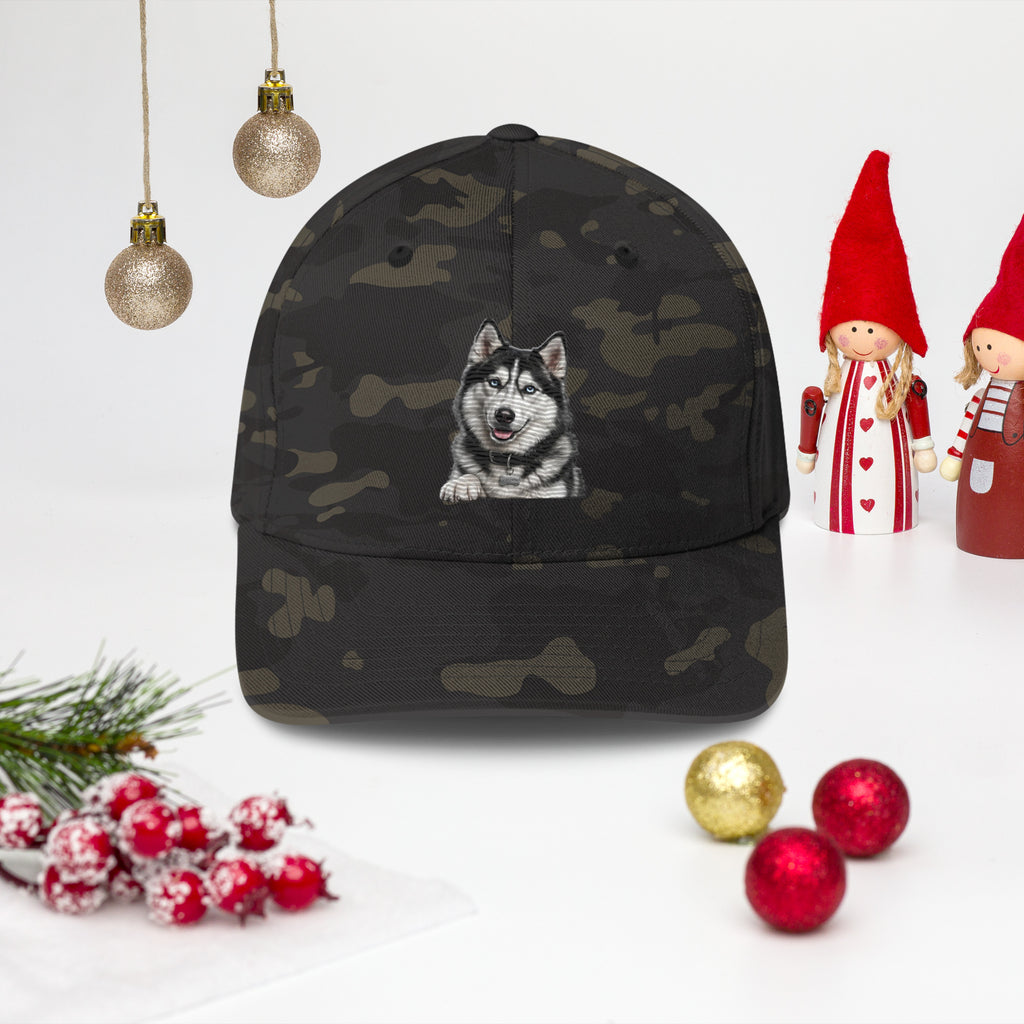 Sheldon the husky front and centre on a multicam black structured twill cap, front view