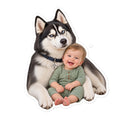 Sheldon the husky sitting beside baby Leonard in a green onesie — kiss-cut vinyl sticker mockup